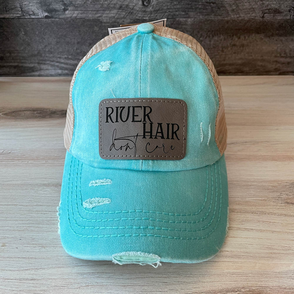 
                  
                    River Hair Don't Care | Women's Distressed Pony Cap with Engraved Leather Patch
                  
                
