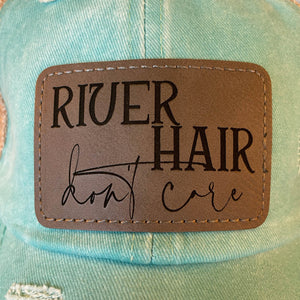 
                  
                    River Hair Don't Care | Women's Distressed Pony Cap with Engraved Leather Patch
                  
                
